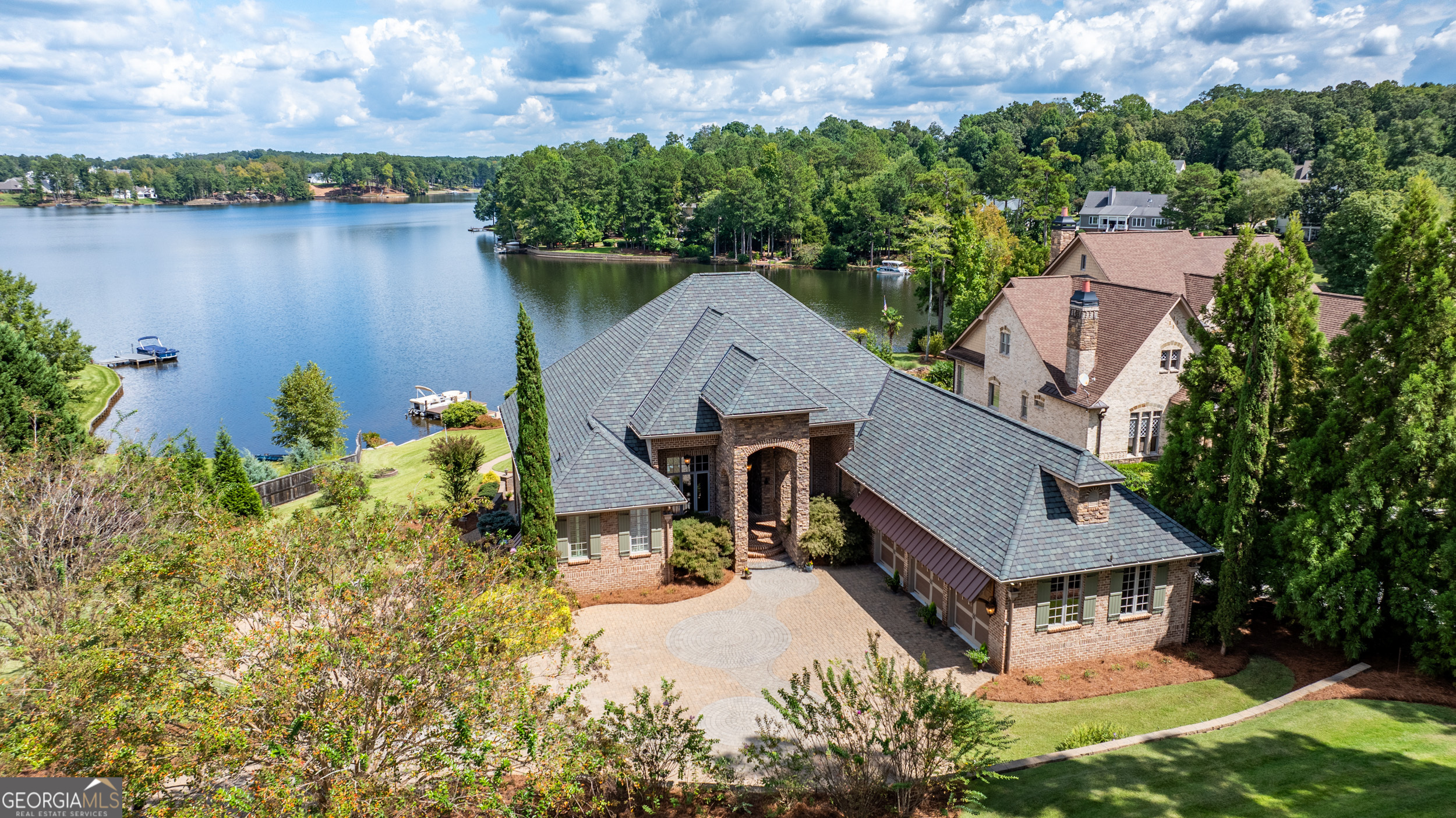 an aerial view of a house with a yard and lake view