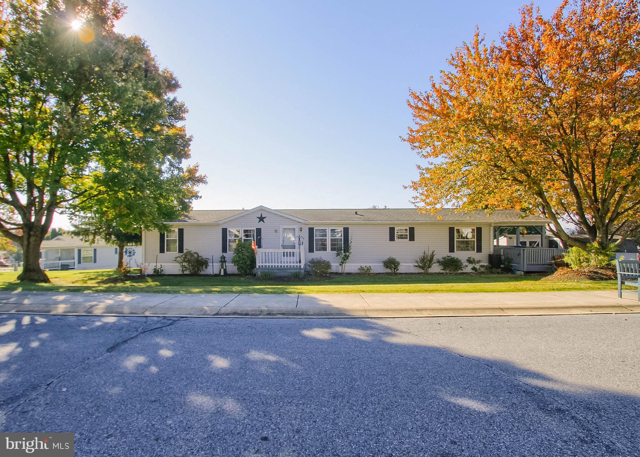 a front view of a house with a yard and trees