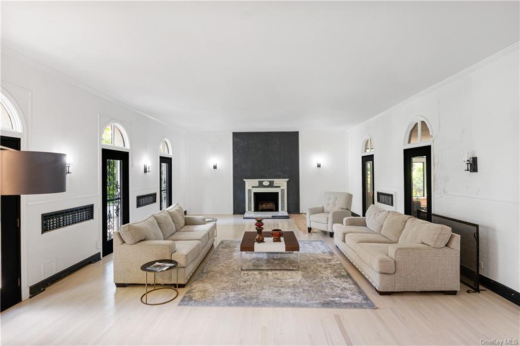 Living room with ornamental molding, light hardwood / wood-style floors, and a fireplace