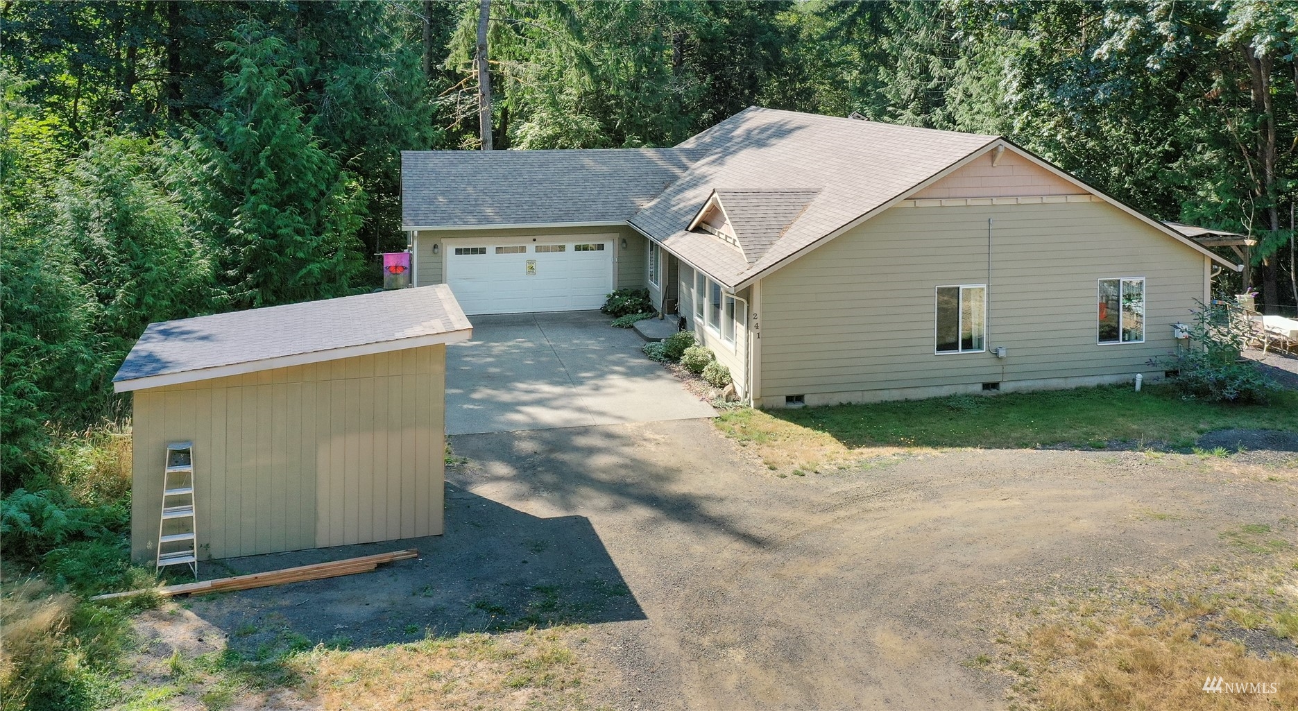 a view of a house with a yard and large tree