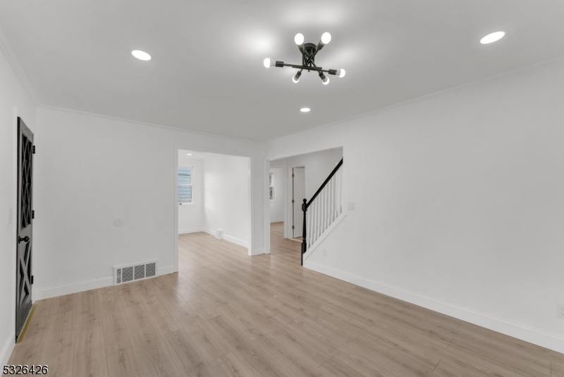 a view of empty room with wooden floor and ceiling fan