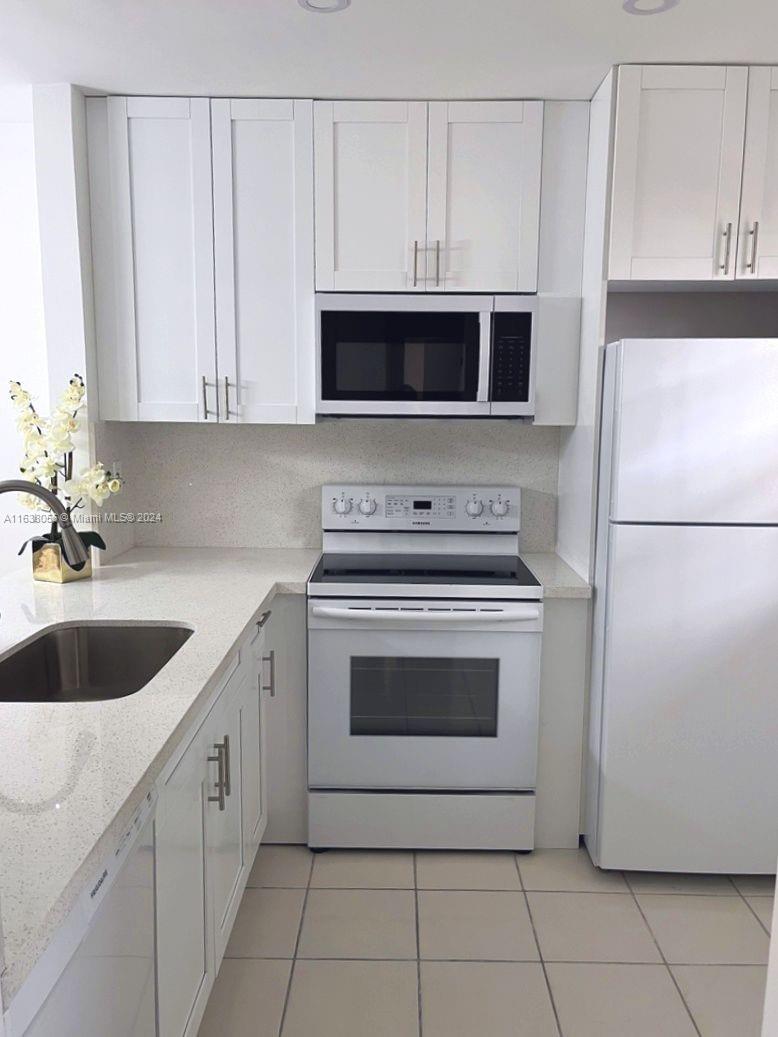 a kitchen with white cabinets and white appliances