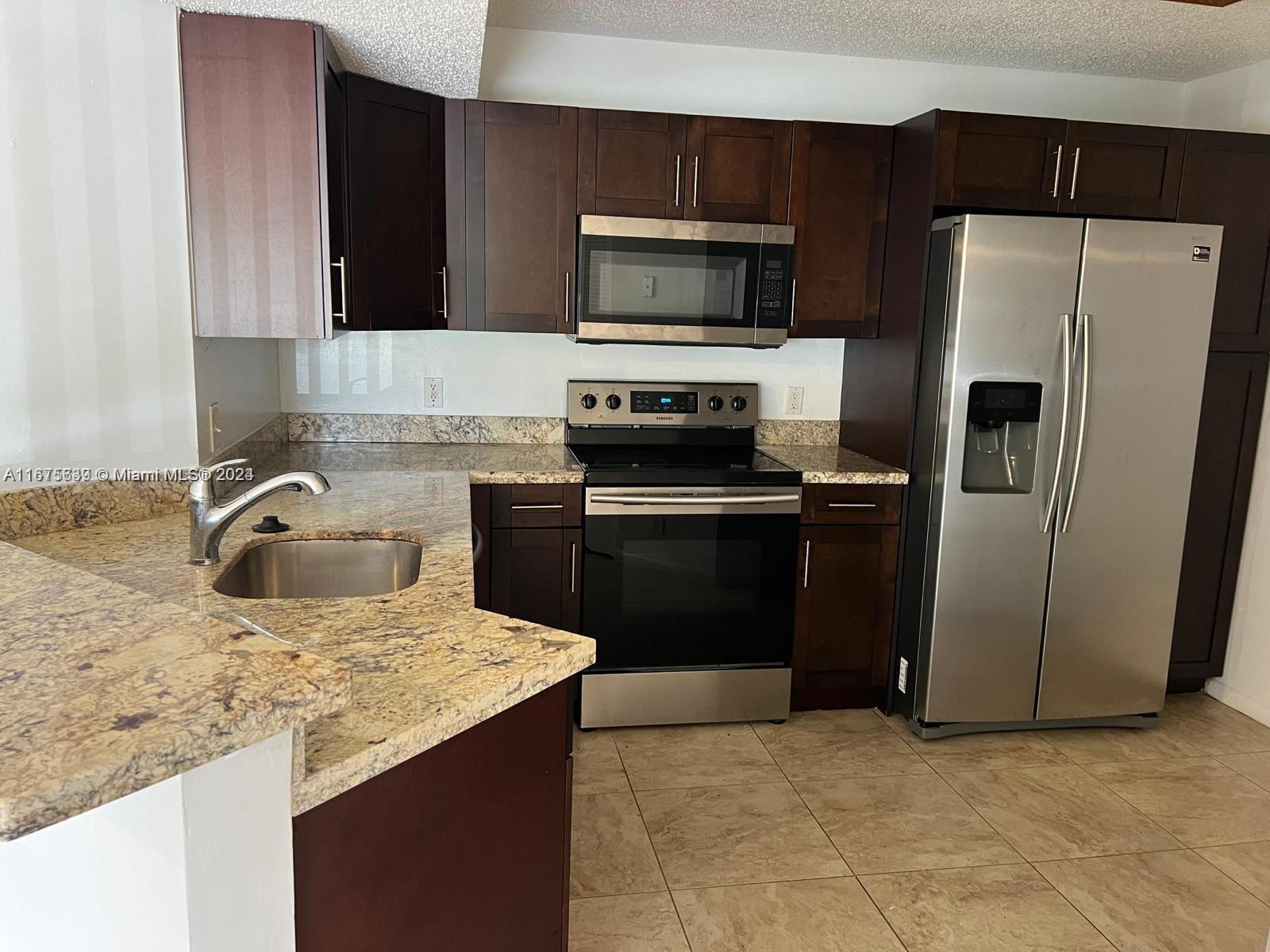 a kitchen with a sink stove and refrigerator