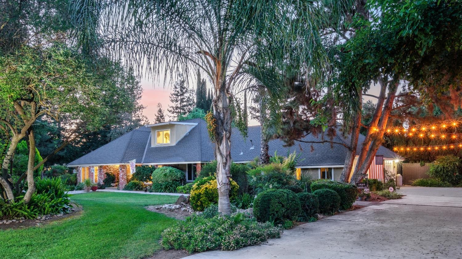 a view of a big house with a big yard and large trees