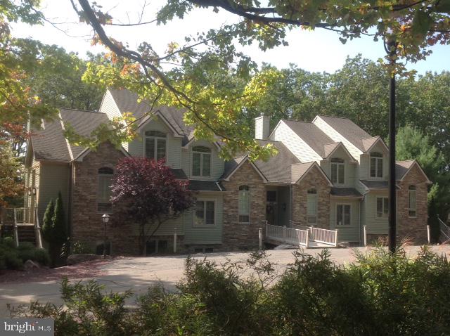 a front view of house with yard and trees around