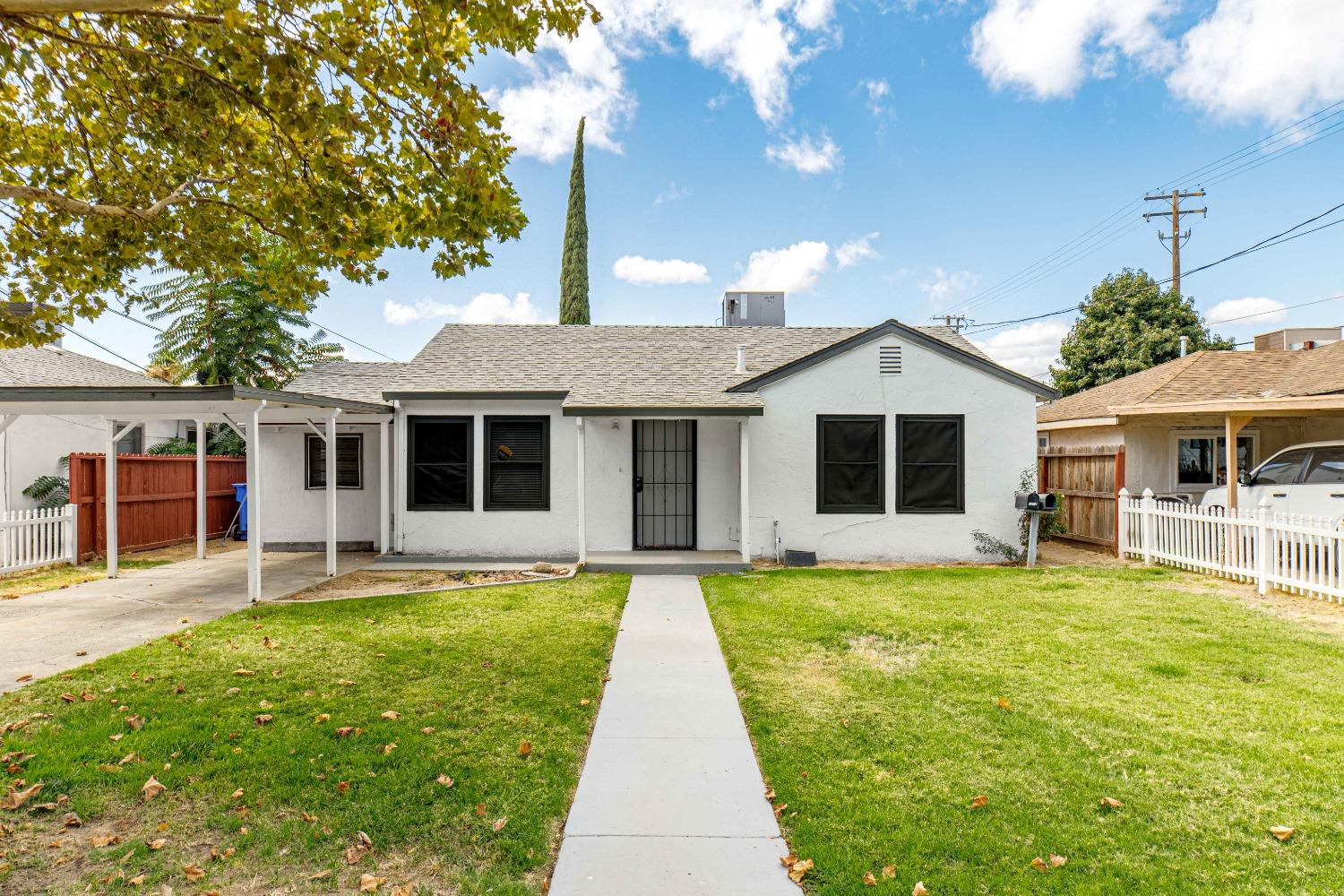 a view of a house with a yard and sitting area