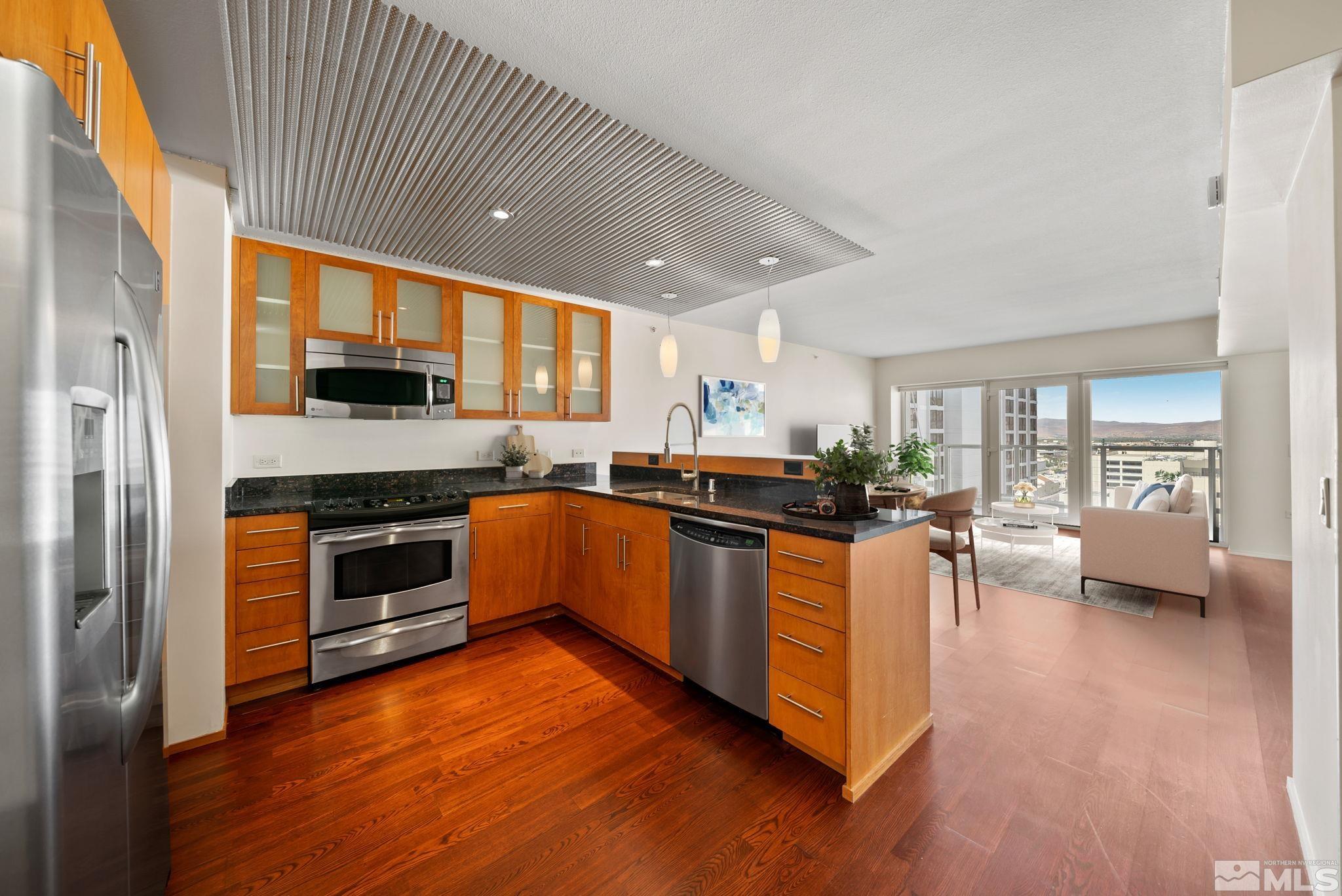 a kitchen with stainless steel appliances granite countertop wooden cabinets a sink a stove and a refrigerator