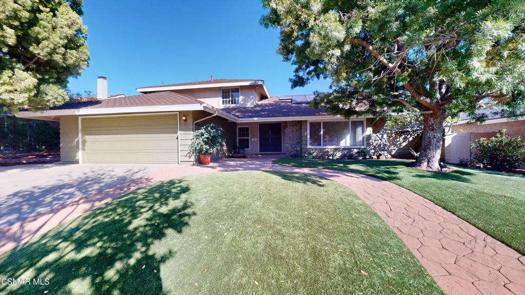 a front view of a house with a yard and a garage