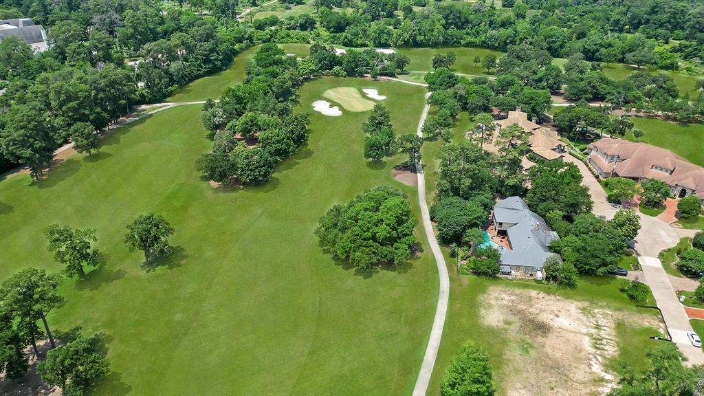 an aerial view of residential houses with outdoor space and trees