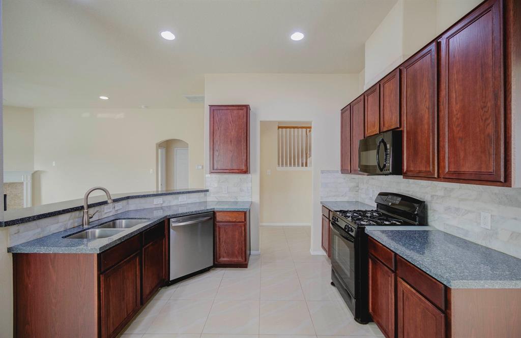 a kitchen with stainless steel appliances granite countertop a sink stove and microwave