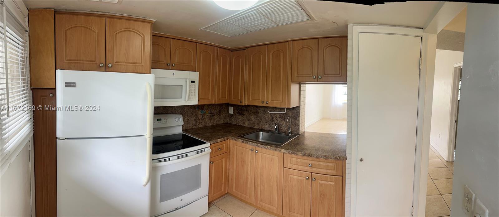 a kitchen with a refrigerator sink and cabinets