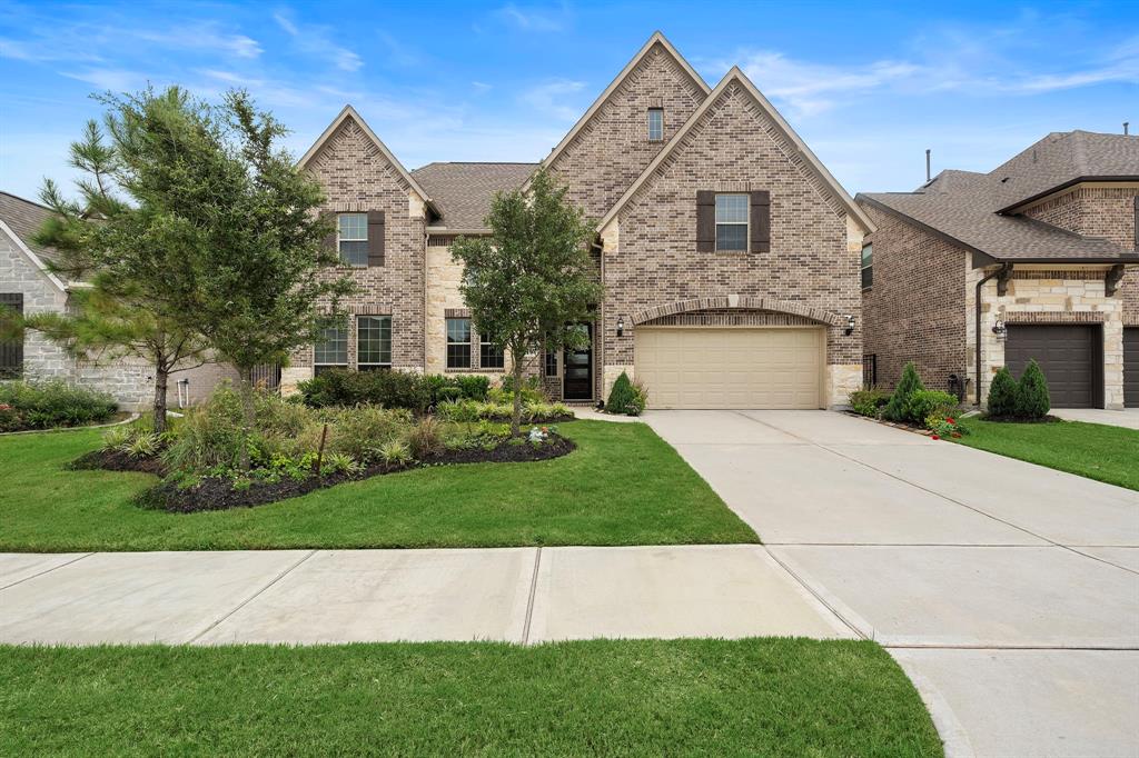 a front view of a house with a garden and yard