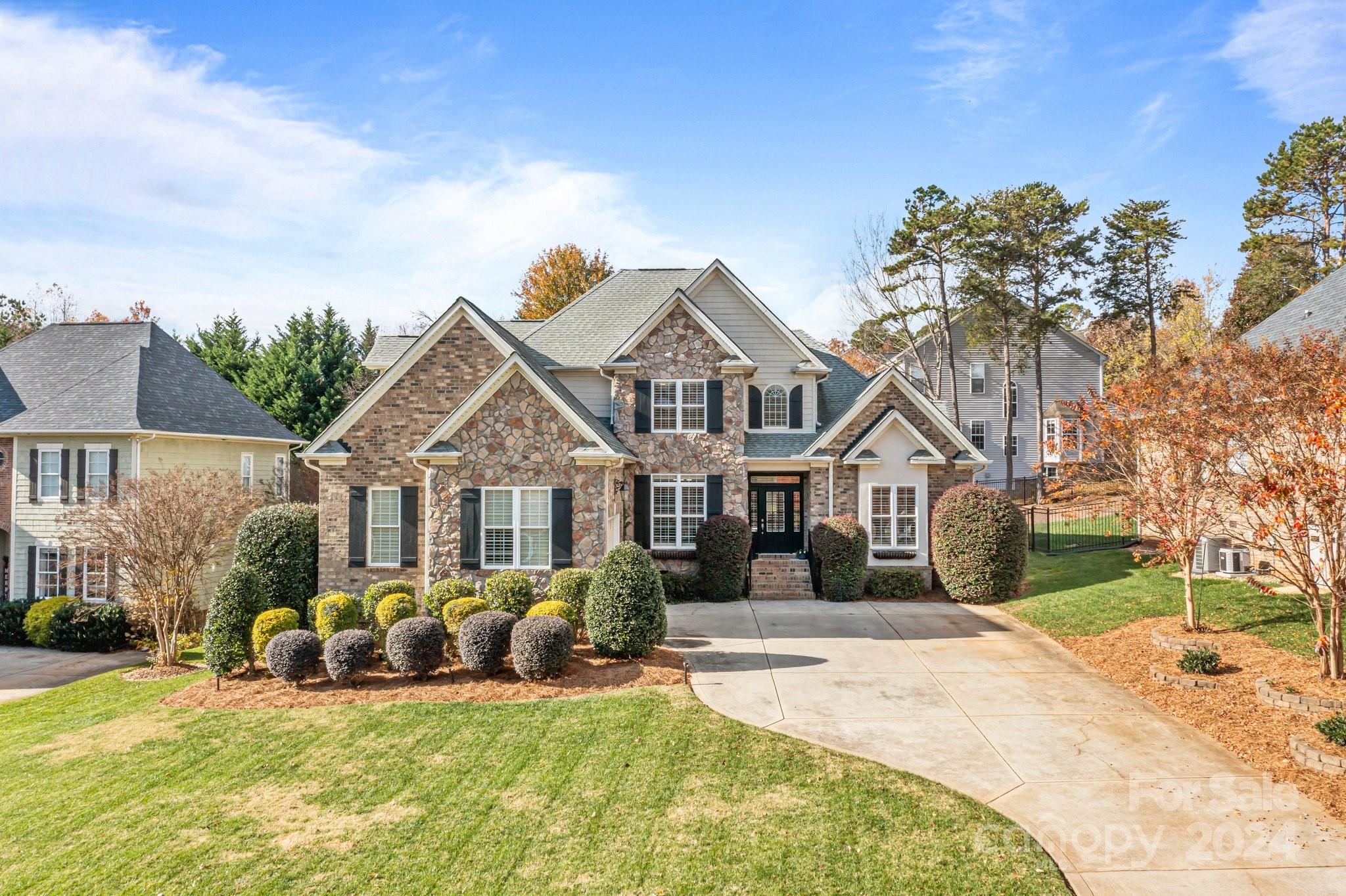 a view of a house with a big yard and large trees