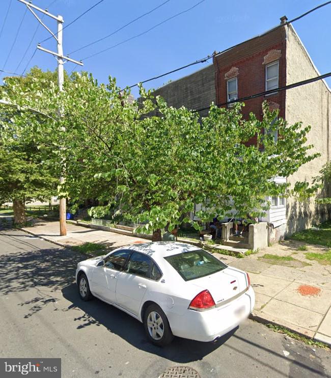 a view of a backyard with a car parked on the road