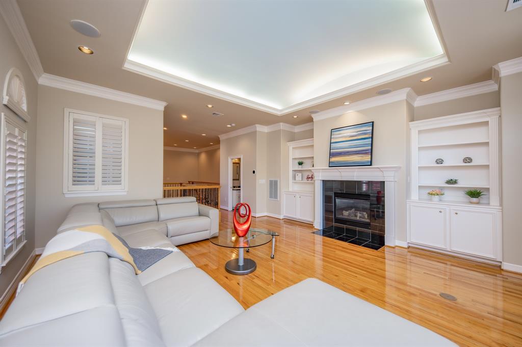 a living room with furniture a fireplace and wooden floor