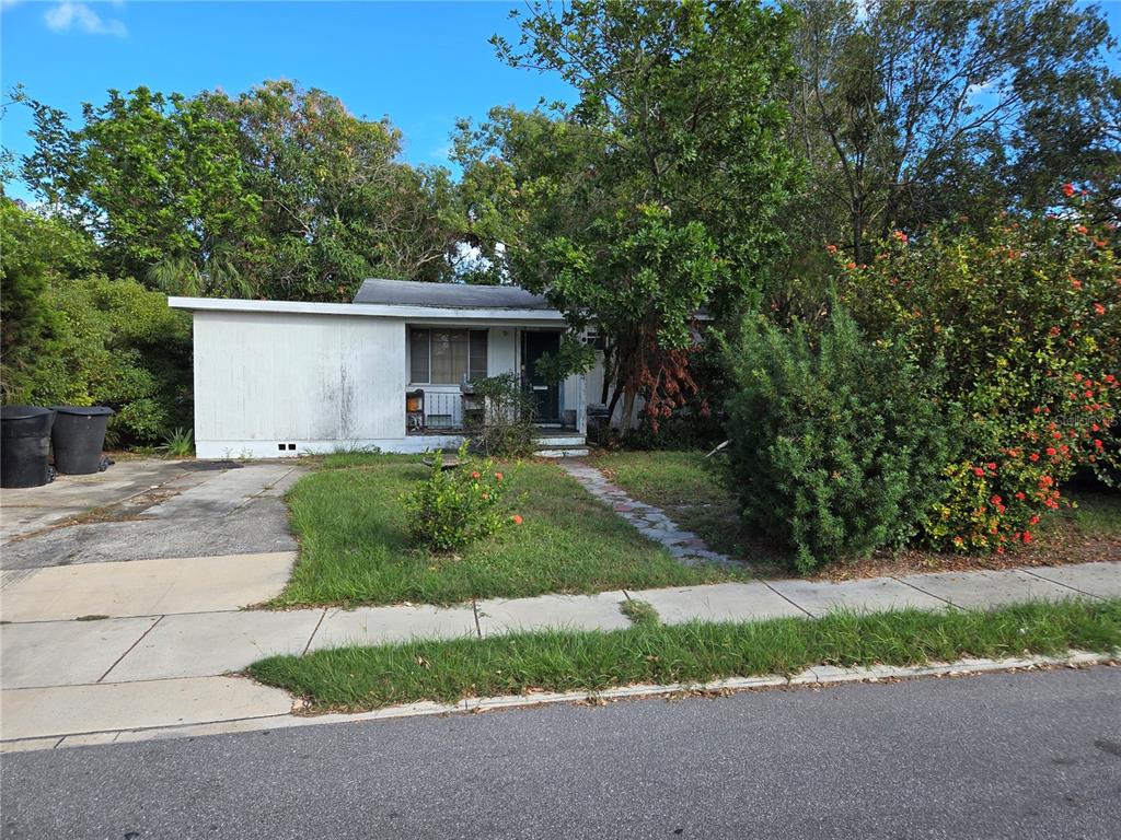 a front view of a house with a yard and trees