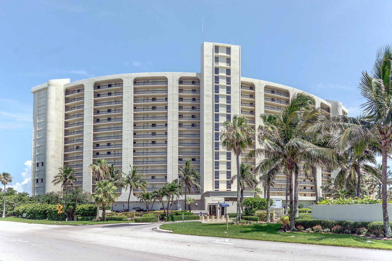 a front view of a building with street view and trees