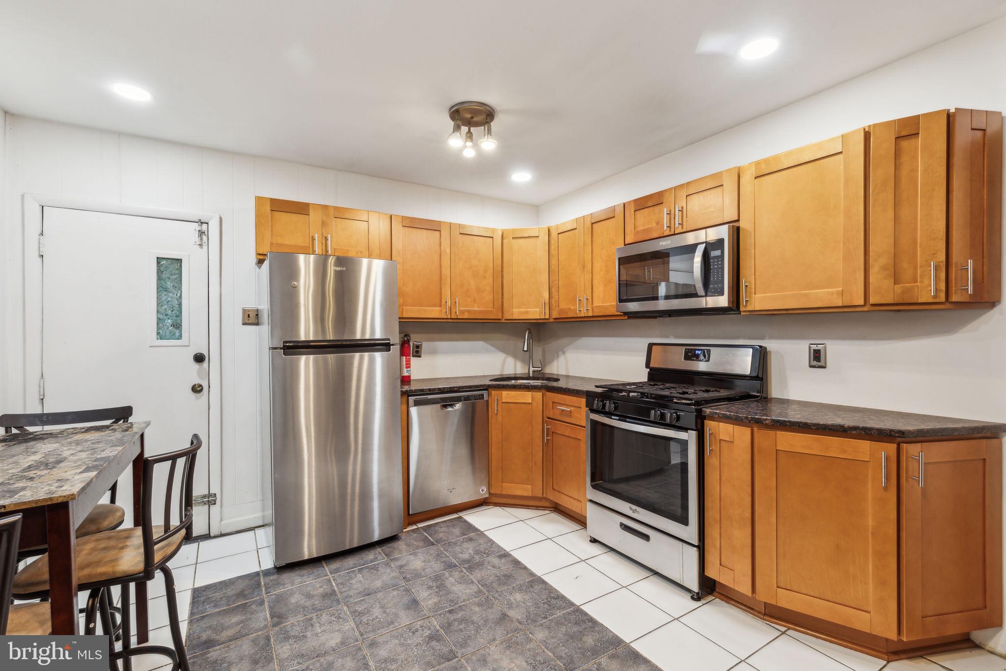 a kitchen with stainless steel appliances granite countertop a refrigerator stove microwave and sink