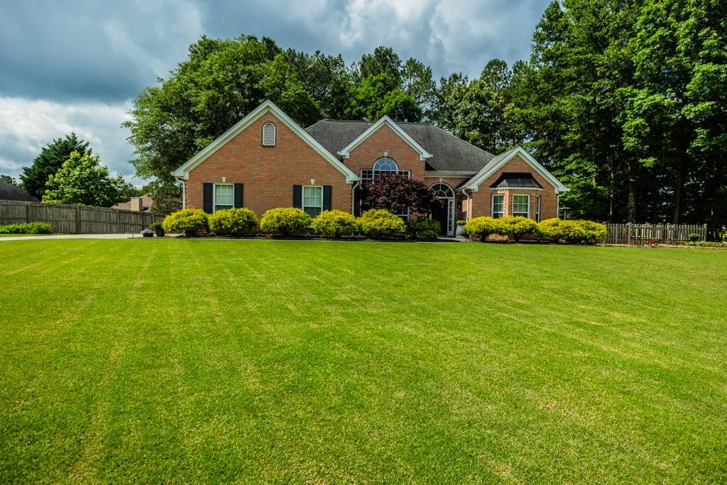 a front view of a house with yard and green space