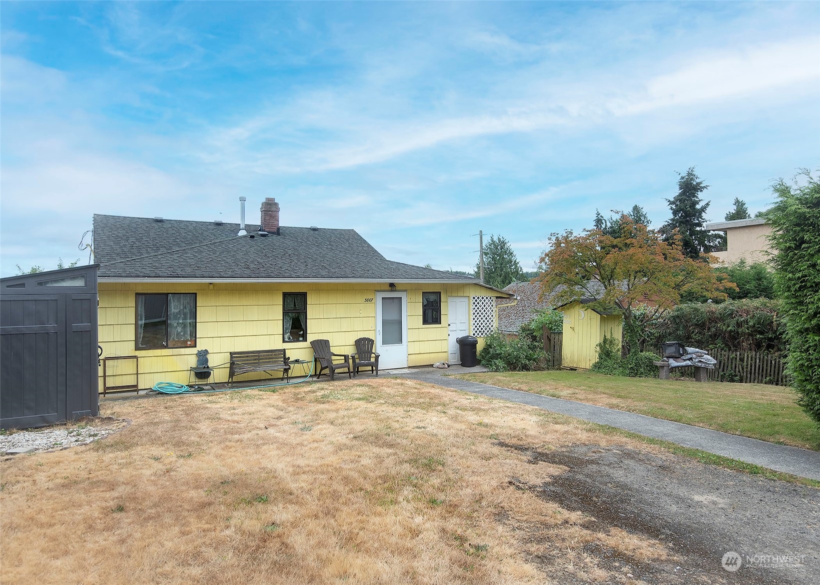 a view of a house with a big yard and large tree