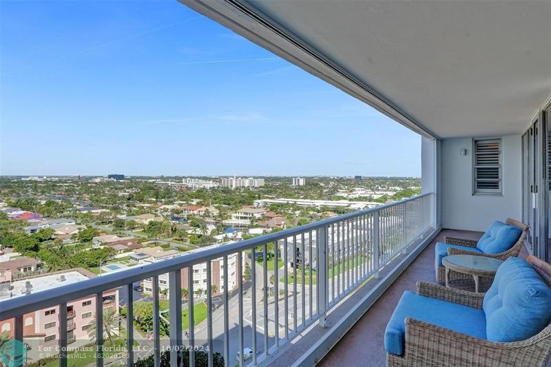 a view of a city from a balcony with furniture