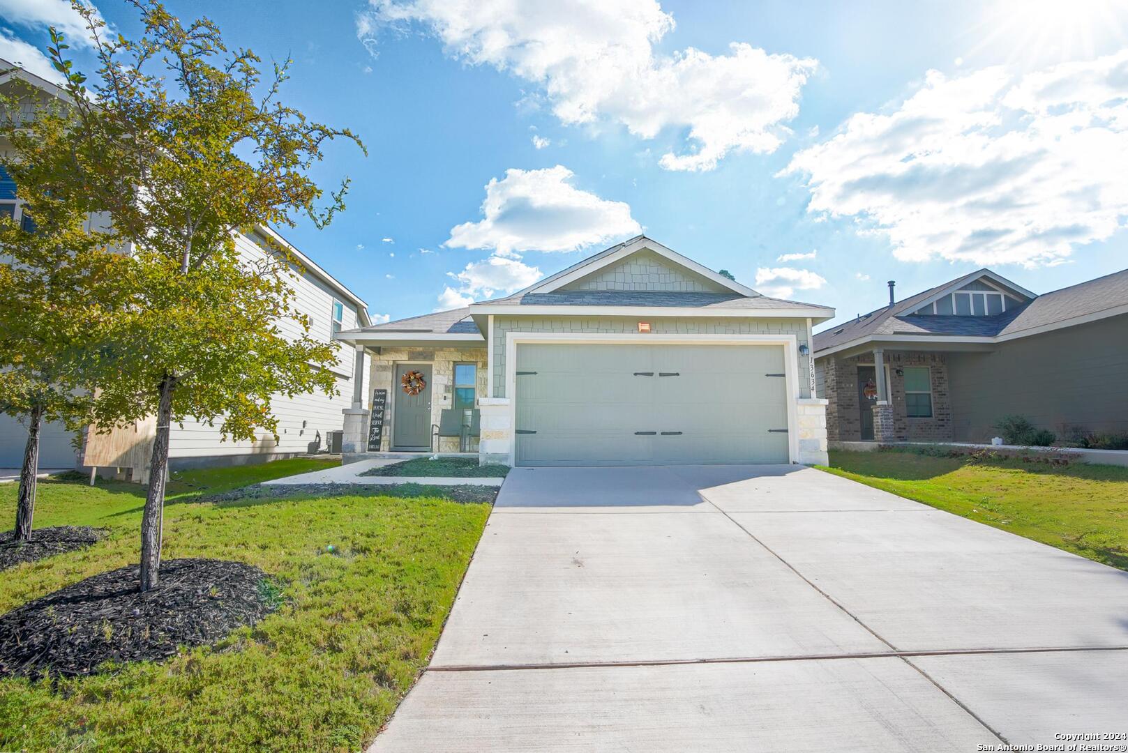 a front view of a house with a yard and garage