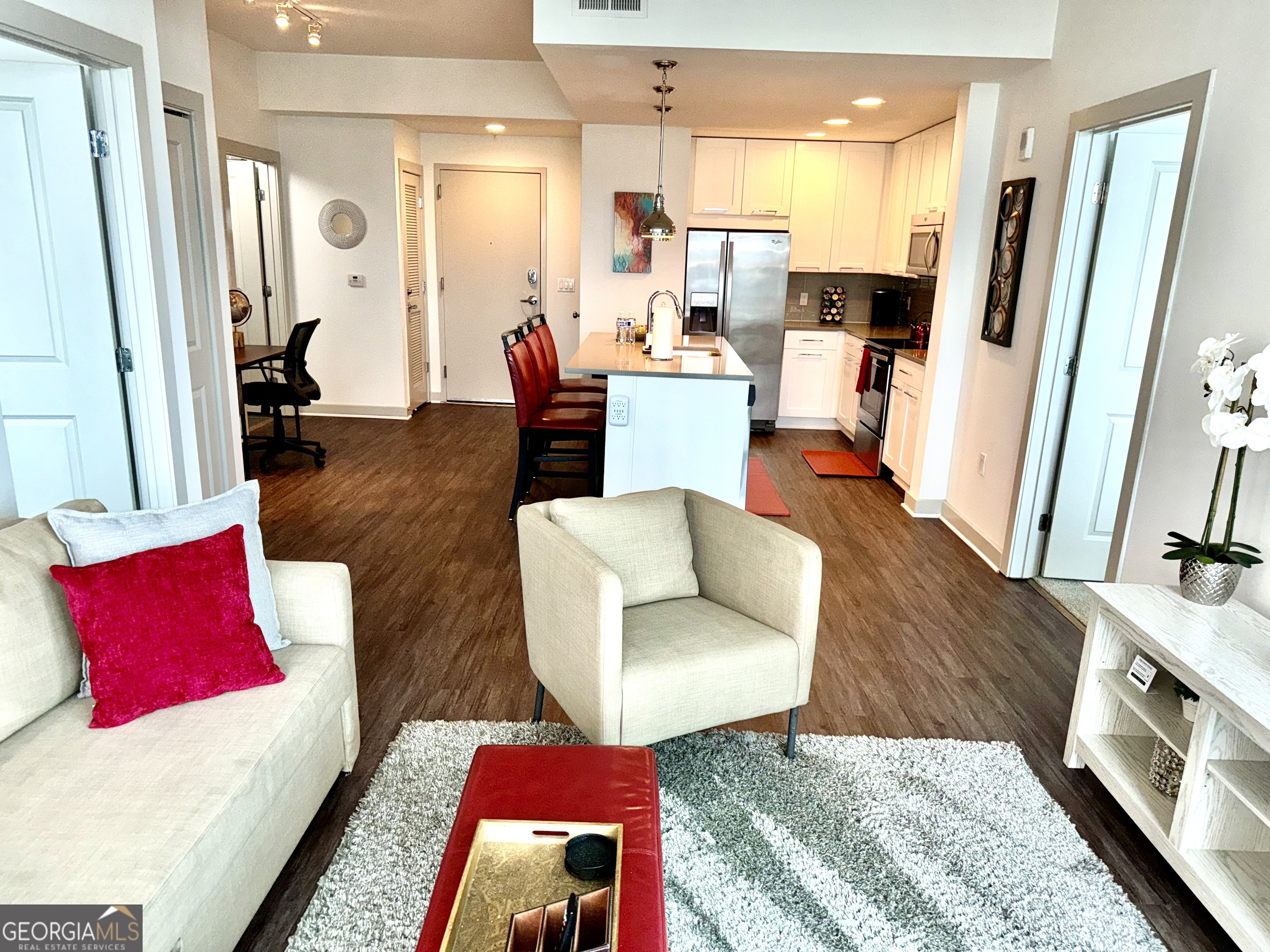 a living room with furniture and a wooden floor