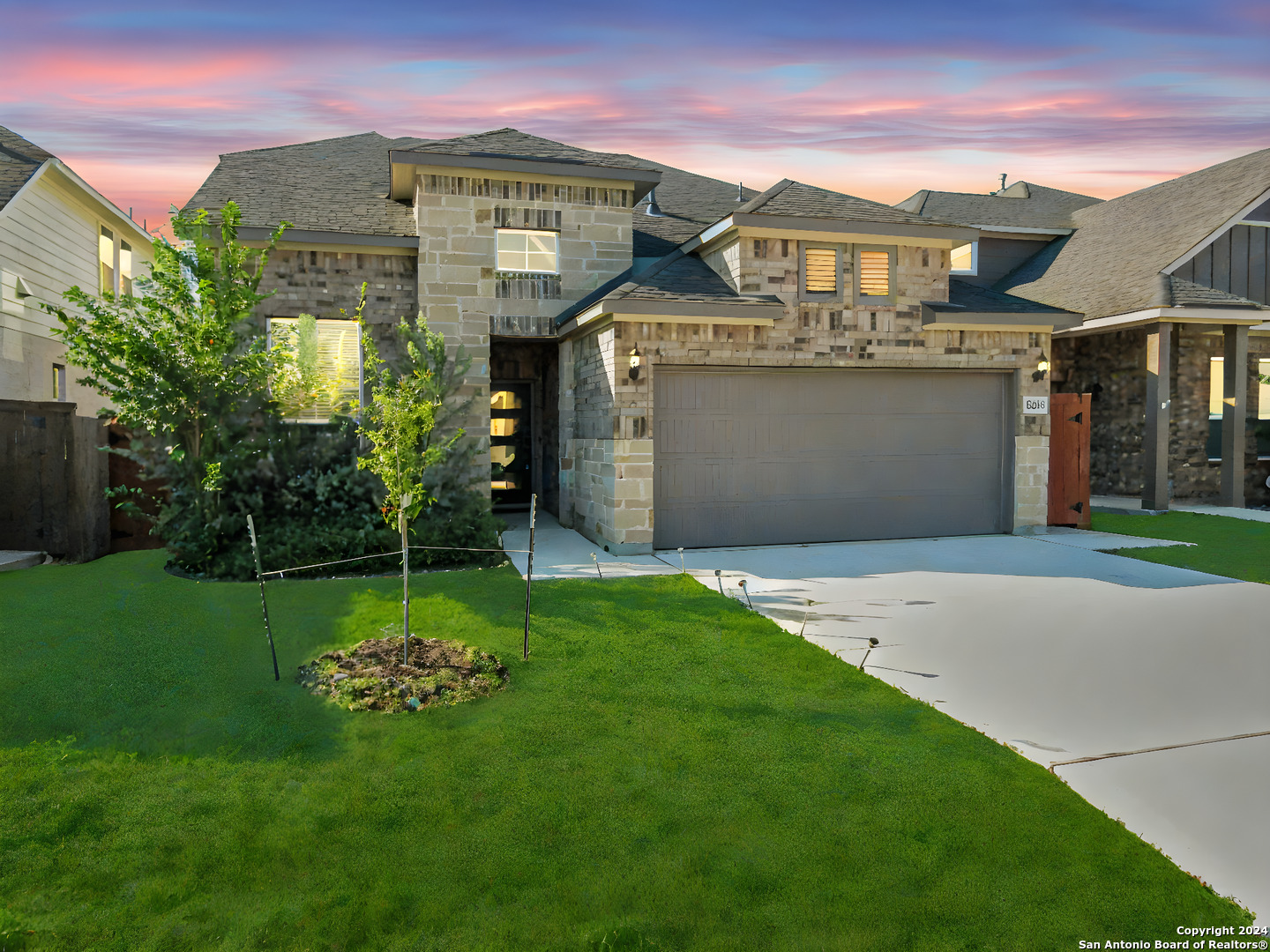 a front view of a house with a garden and yard