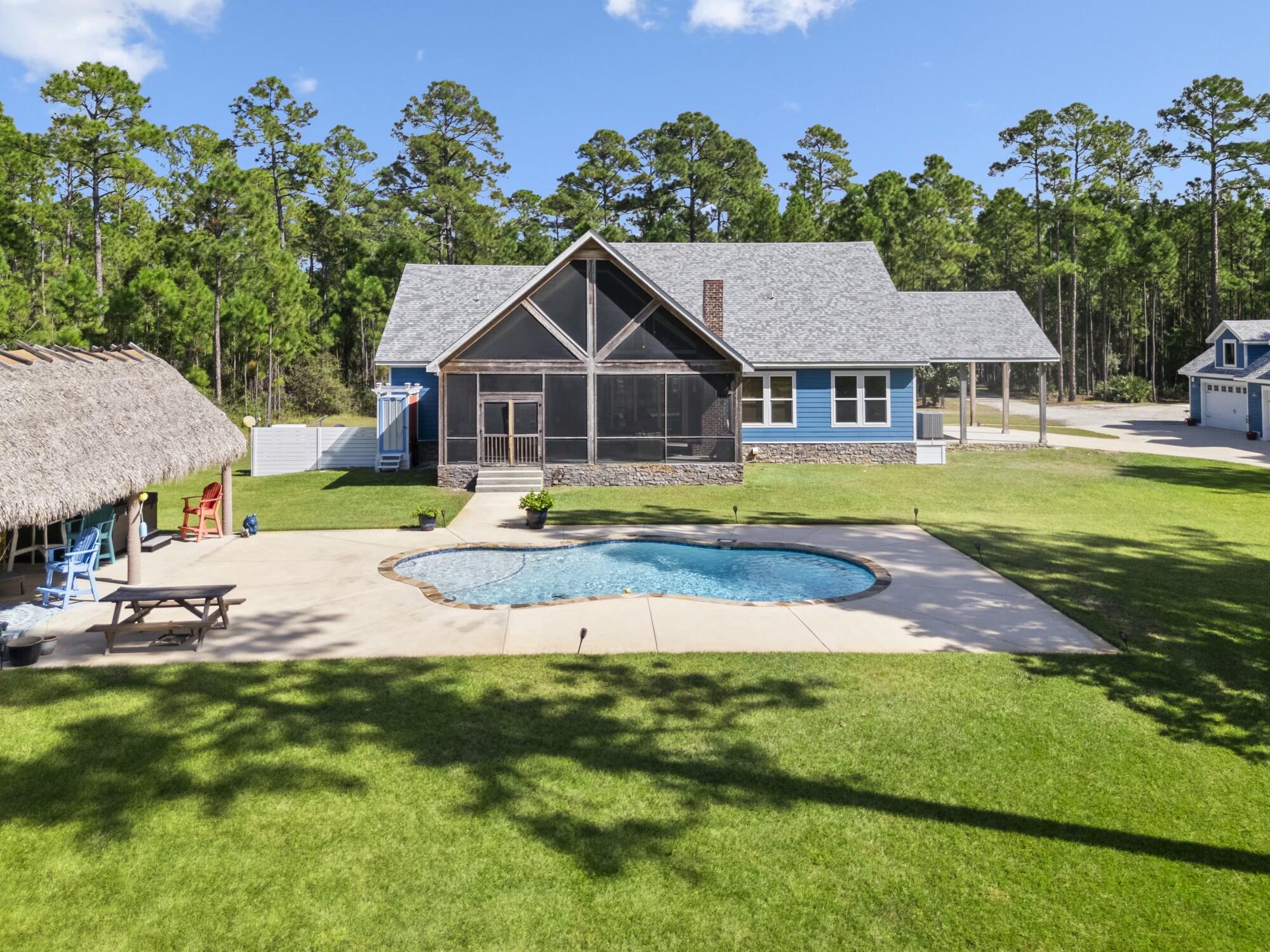 a view of a house with a big yard and large trees