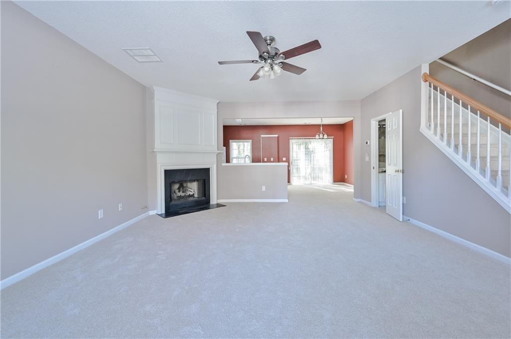 a view of an empty room with a fireplace and a window