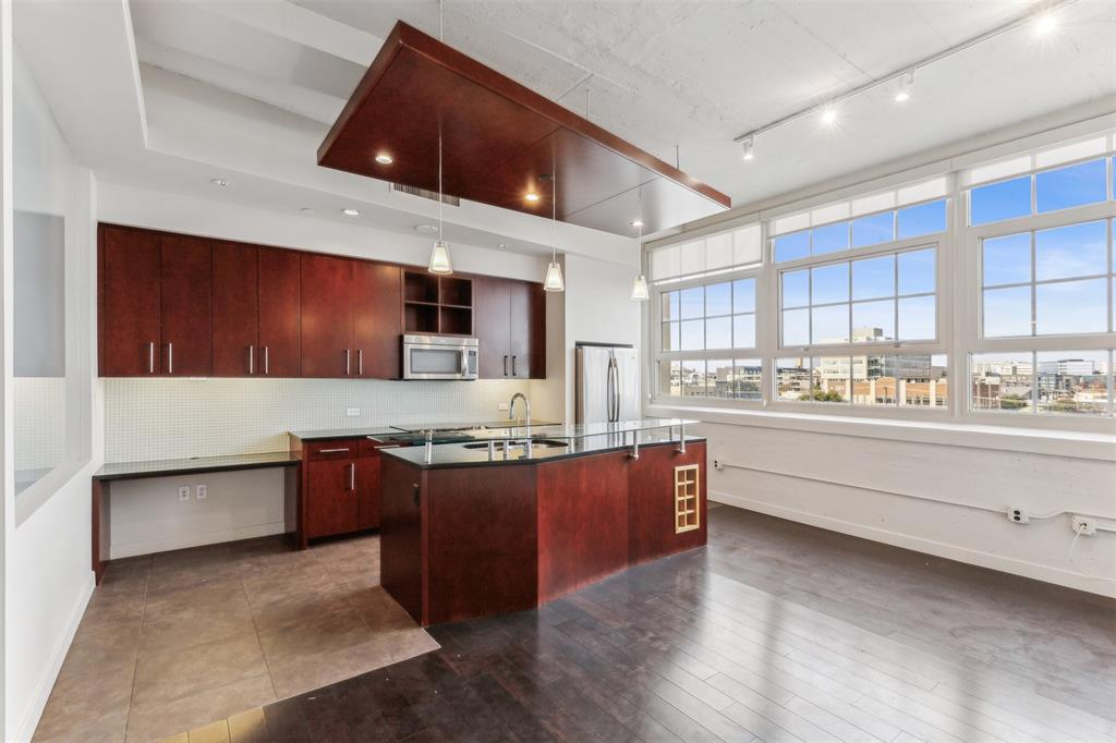 a large kitchen with stainless steel appliances kitchen island granite countertop a stove and a sink