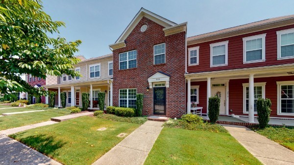 front view of a brick house with a yard