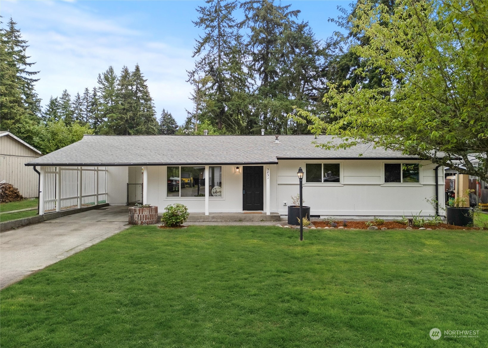 a front view of a house with a yard and trees