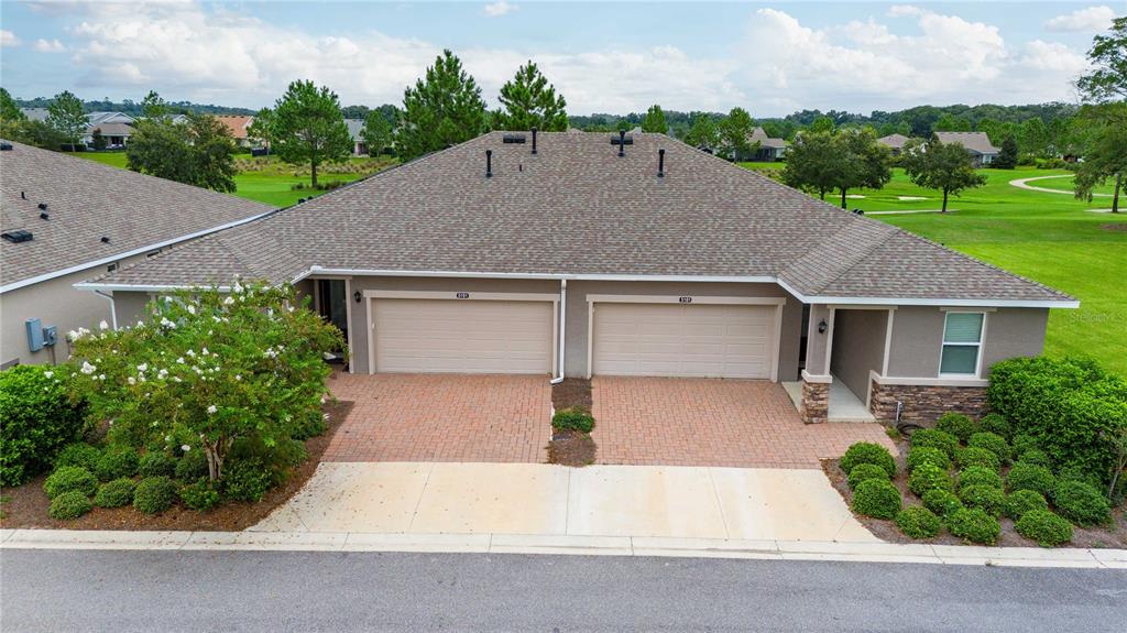 front view of house with a yard and trees in the background