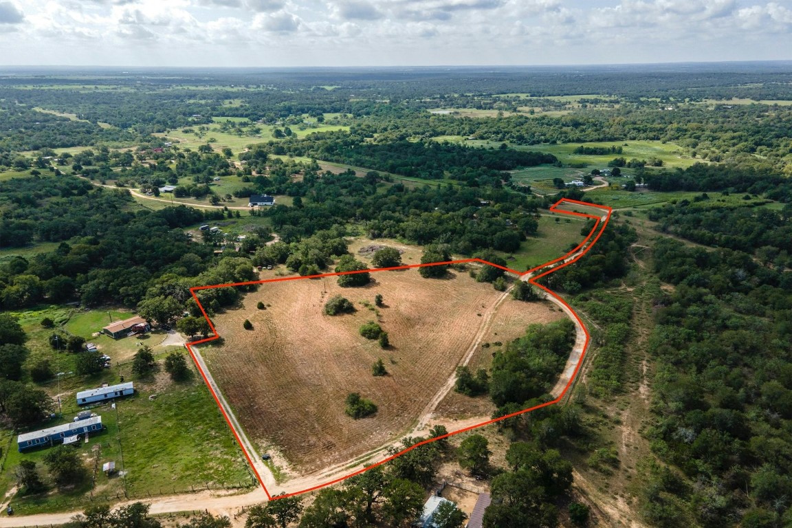 an aerial view of a house with a yard and lake view