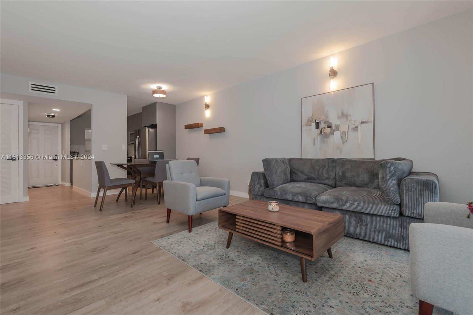 a living room with furniture and a dining table with kitchen view