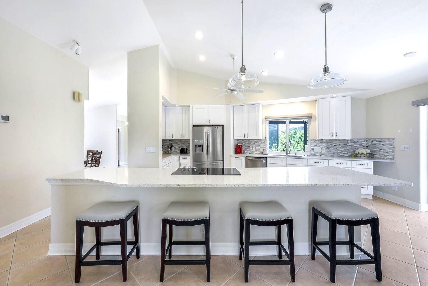 a kitchen with stainless steel appliances kitchen island a chandelier and refrigerator