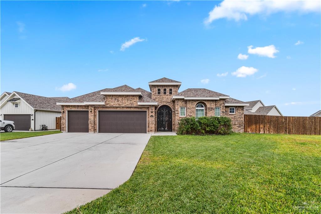 View of front of property featuring a front yard and a garage