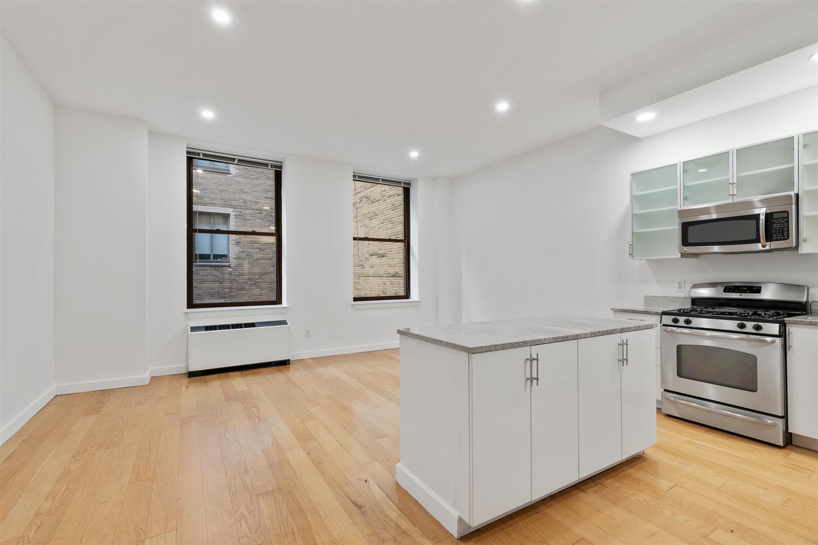 a view of kitchen with stainless steel appliances granite countertop a stove and a sink