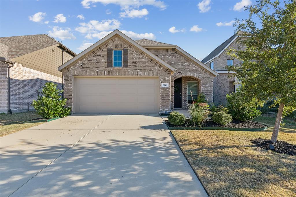 a front view of a house with a yard and a garage