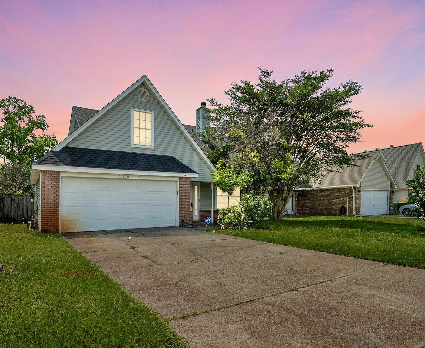 a front view of house with yard and trees