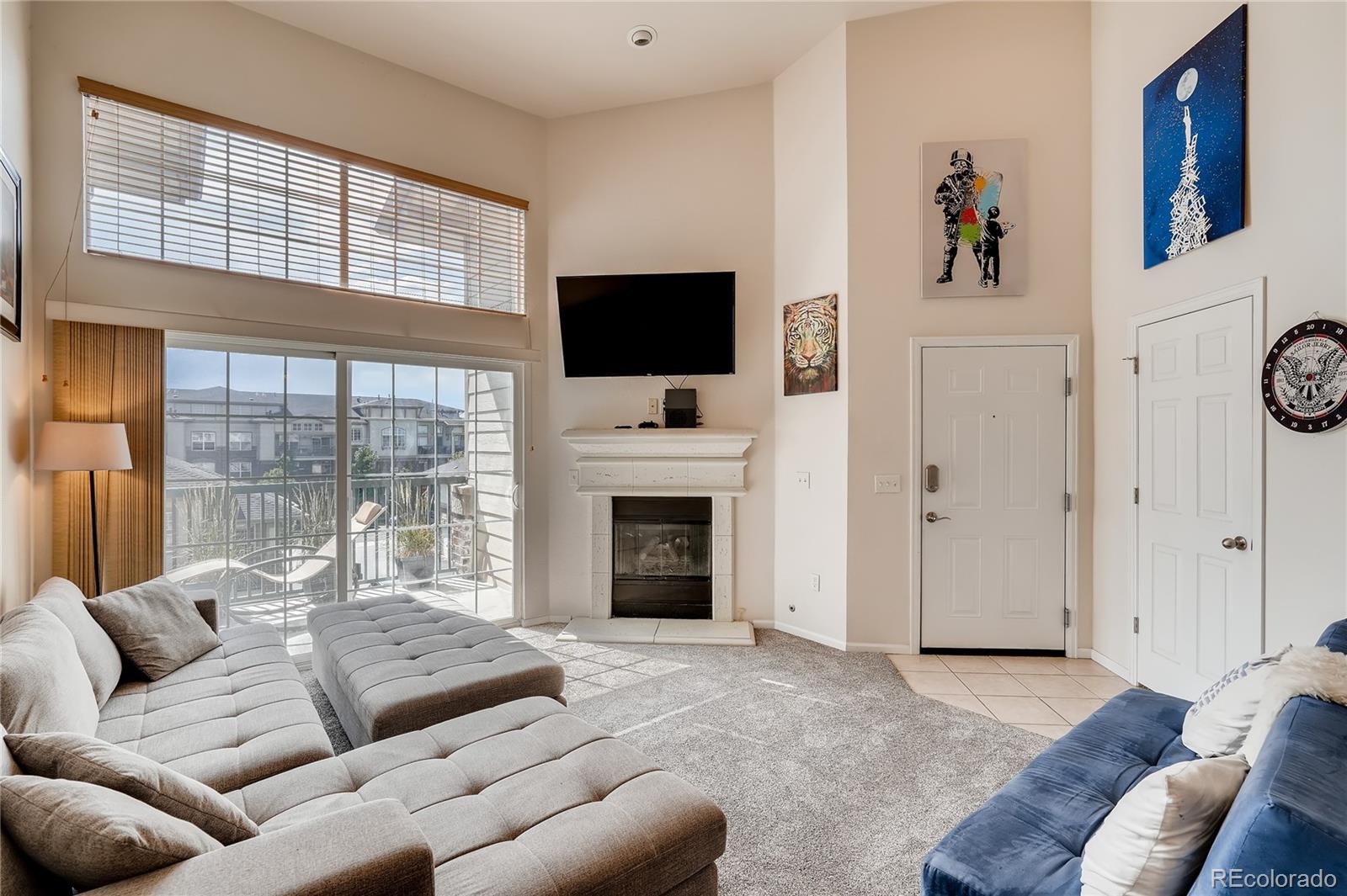 a living room with furniture a flat screen tv and a fireplace