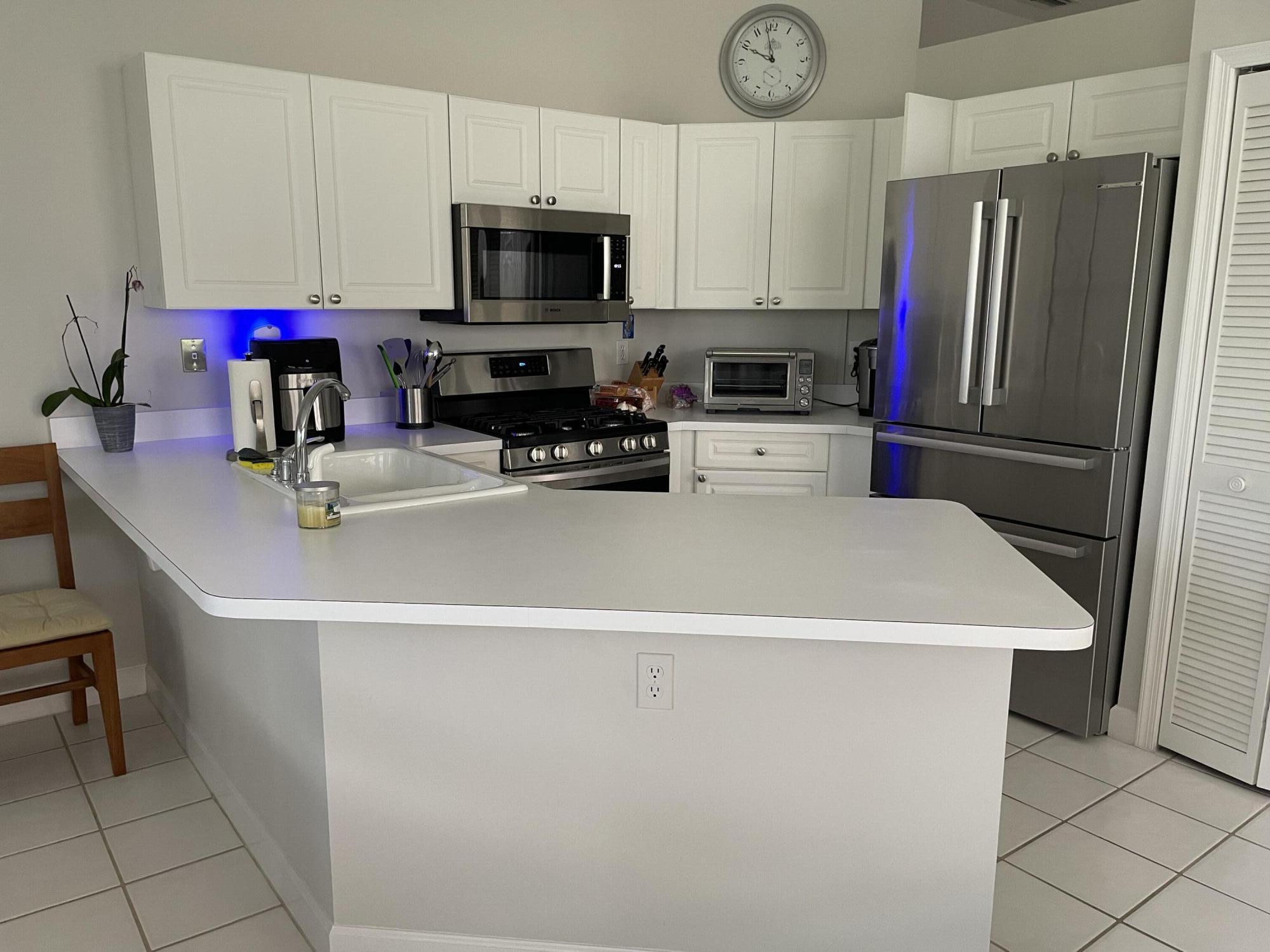 a kitchen with stainless steel appliances a refrigerator sink and microwave