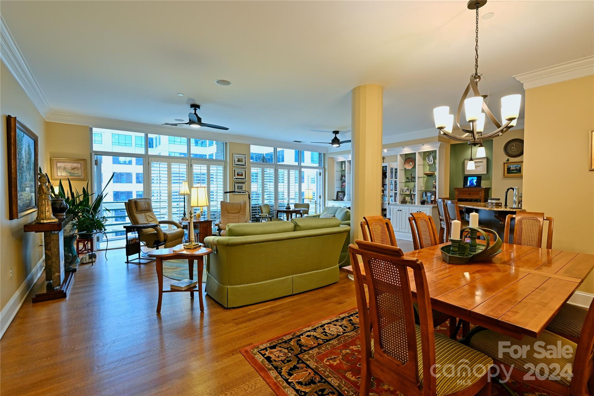 a living room with furniture kitchen view and large windows