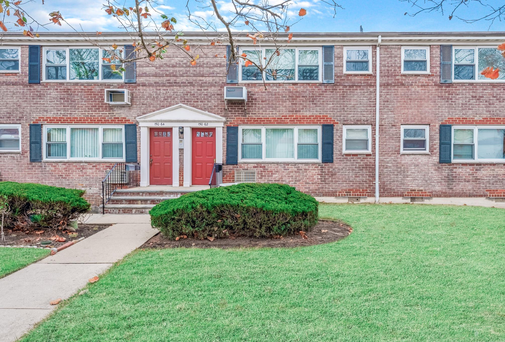 front view of a brick house with a yard