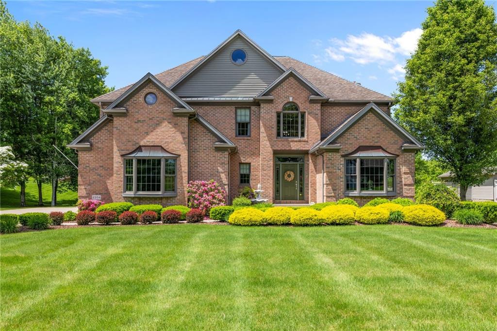 a front view of a house with a big yard and potted plants