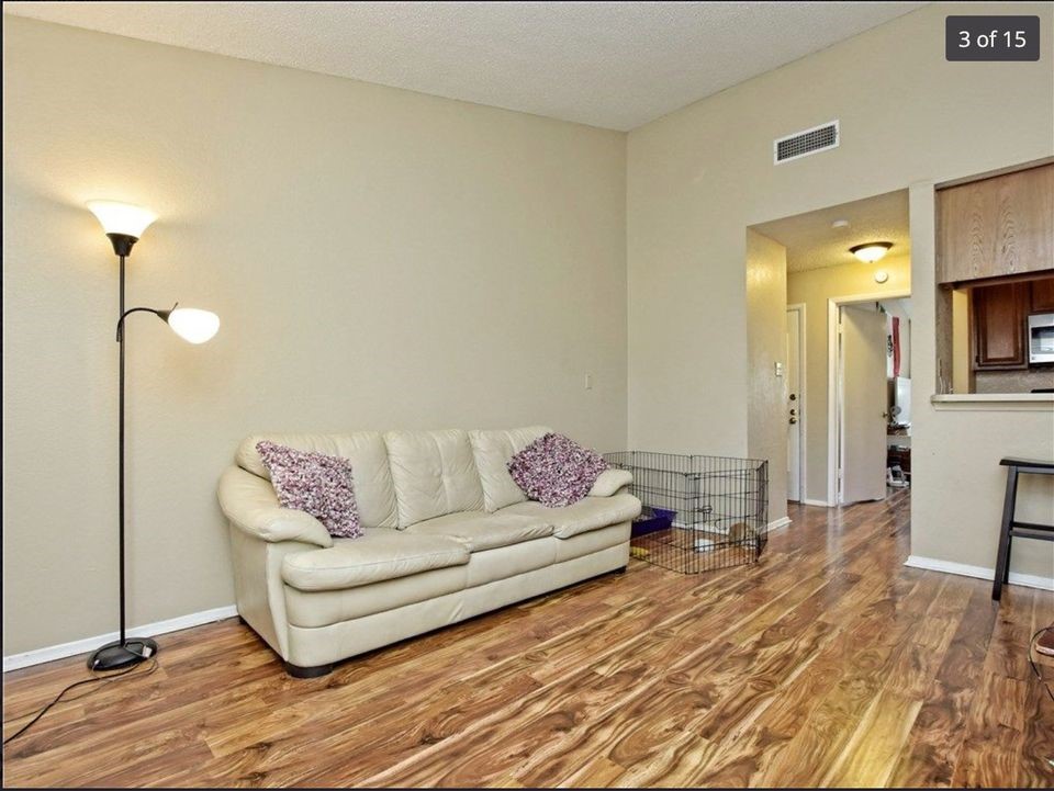 a living room with furniture and a wooden floor