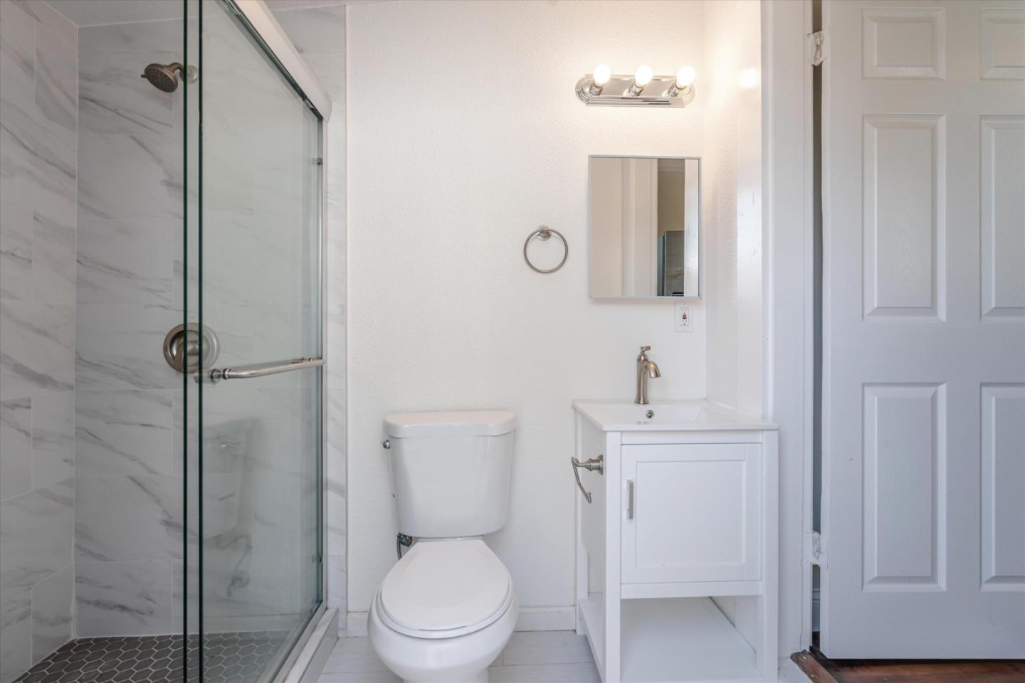 a bathroom with a toilet a sink a vanity and mirror