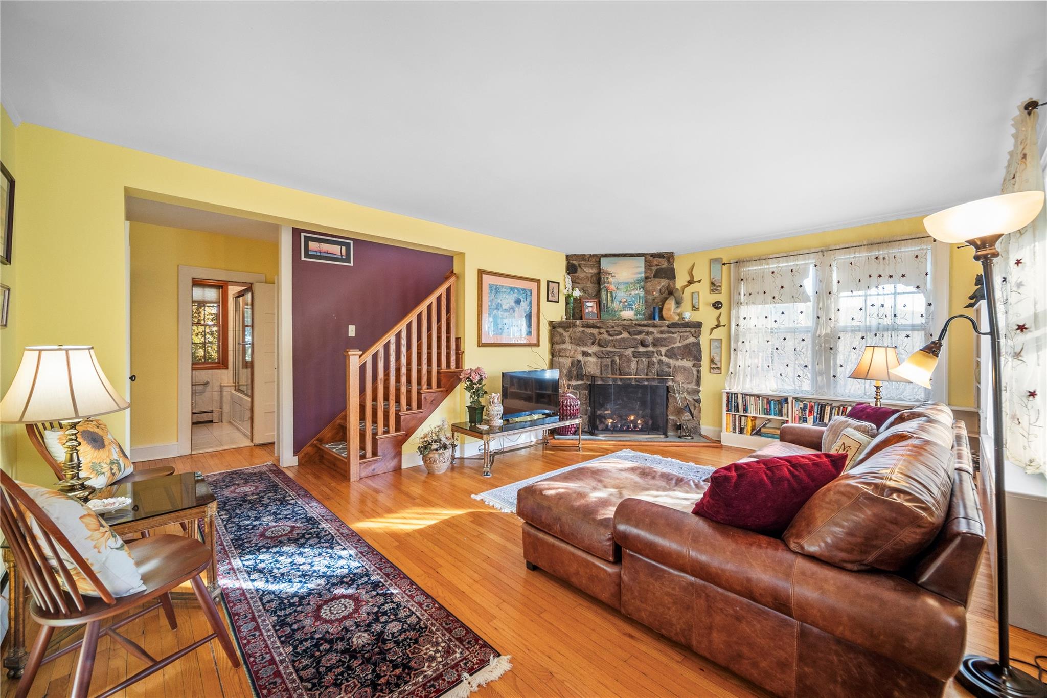 Living room with hardwood floors and gas stone fireplace