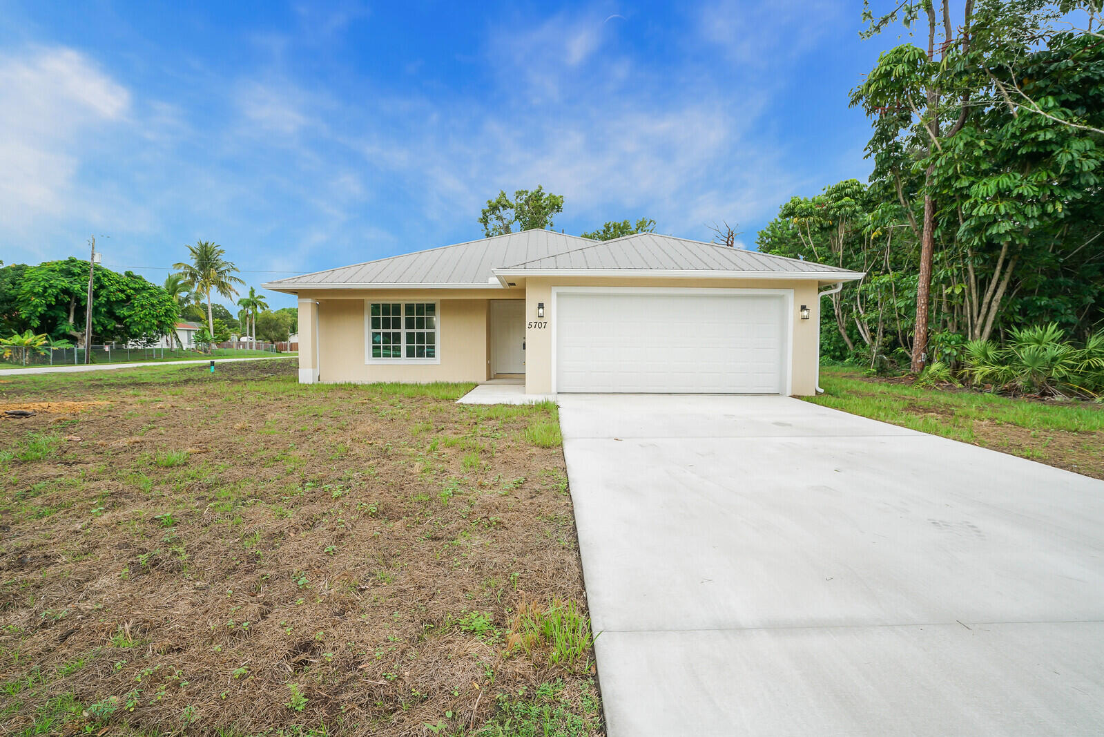 a front view of a house with a yard and trees